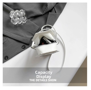 Internal view showing storage space for phone and lipstick in the white house-shaped bag