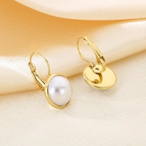 Elegant gold titanium steel hoop earrings with white shell pearl on luxury satin