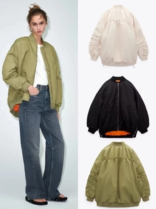 Detail der Bomberjacke in Oliv, Schwarz und Beige mit kontrastierendem orangefarbenem Futter