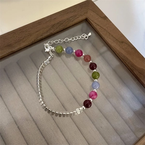 Detail of colorful beads and silver square metal spacers on an adjustable bracelet