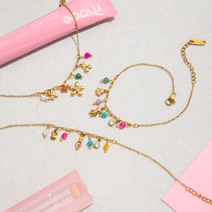 Detail of 18K gold plated necklaces featuring colorful beads and animal paw pendants