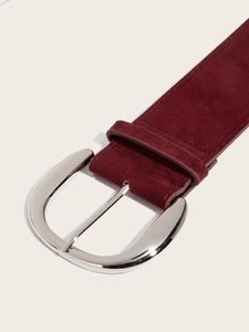 Detailed close-up of wide burgundy suede belt with oval silver buckle for women
