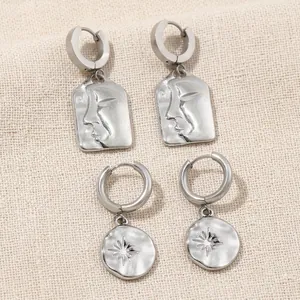 Artistic silver stainless steel face relief and sunburst earrings on silk fabric