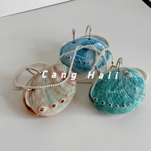Three creative shell-shaped bags in blue and green with natural abalone shell texture and pearl strap