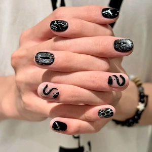 Short round press-on nails with 3D snakes, silver cat-eye glitter and black gothic art