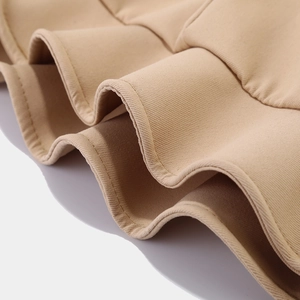 Macro view of khaki twill fabric layers and fine stitching on the pleated ruffles