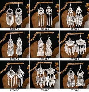 Collection of nine bohemian silver-style leaf and feather tassel earrings in a grid