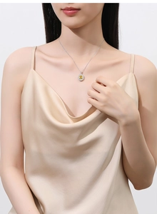 Close-up of S925 silver necklace featuring a yellow gemstone pendant with diamond halo