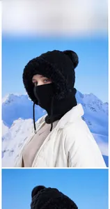 Detail of black winter knit balaclava with plush faux fur trim and soft pom-poms