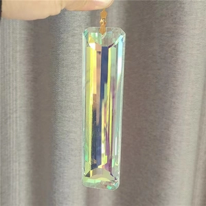Macro shot of rectangular faceted crystal prism pendant creating rainbow light effect
