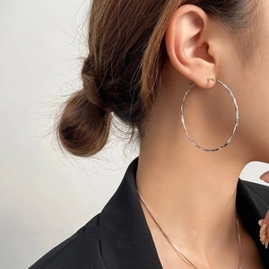 Minimalist silver twist hoop earrings with spiral texture shown on model