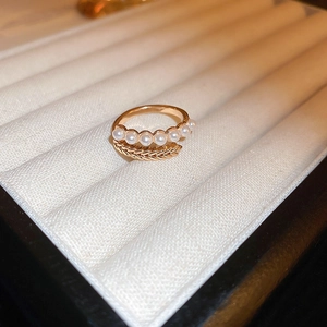 Detail view of gold adjustable ring featuring delicate leaf motifs and pearl inlay