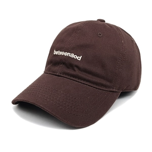 Detailed view of the dark brown cotton baseball cap with white betweenaod embroidery