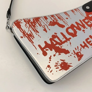 Detail of silver metallic Halloween bag featuring realistic red blood splatter graphics