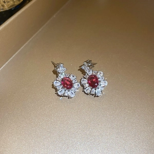 Macro di orecchini a lobo con rubino ovale e petali di zircone su montatura in argento