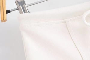 Close-up of white knitted fabric texture and drawstring waist detail on casual shorts