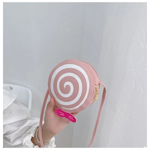 Pink lollipop-shaped kids crossbody bag with magenta bow detail shown in hand