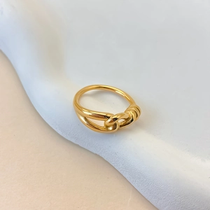 Vista macro dell'anello a nodo minimalista in acciaio inossidabile dorato su supporto