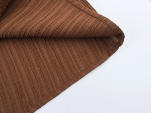 Macro shot of brown vertical stripe pleated fabric detail with high-quality stitching