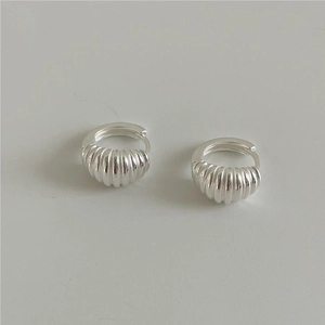 Detail shot of silver croissant hoop earrings with a textured threaded metal surface