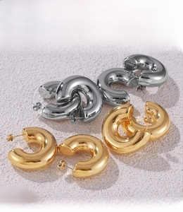 Detailed macro view of PVD electroplated C-shape hoop earrings in gold and silver finish
