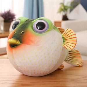 Gros plan sur la coque en peluche de poisson-globe avec tissu doux vert et jaune réaliste