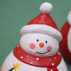 Primer plano de un muñeco de nieve navideño con textura de madera y accesorios rojos de invierno
