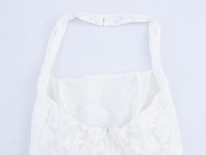 Close-up of white floral lace dress featuring halter neck buckles and invisible back zipper