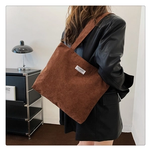 Detailed texture of brown corduroy tote bag with 'FASHION' label and urban retro design