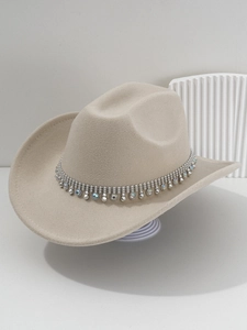 Detail of beige cowboy hat featuring silver beaded rhinestone band and soft fabric texture