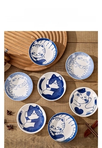 Close-up of Japanese ceramic sauce dishes with cute blue cartoon cat patterns