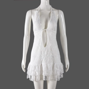 Detail of white lace tiered dress with halter neck tie and hollow out embroidery texture