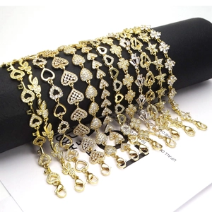 Collection of gold adjustable heart and clover zircon bracelets on a black display stand