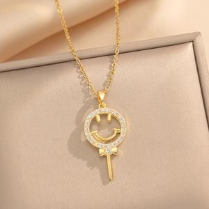 Collier en acier titane avec sourire sucette et zircons brillants sur fond beige élégant
