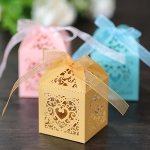 Detailed laser-cut heart pattern on gold candy box with silk ribbon bow decoration
