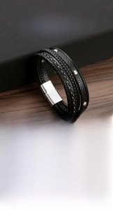 Close-up of multi-layer black leather bracelet with stainless steel magnetic clasp and studs