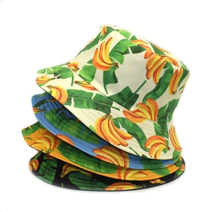 Vertical stack of tropical banana leaf print bucket hats in four assorted colors