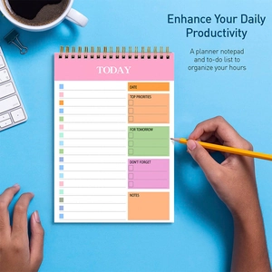 Flat lay of daily spiral planner with productivity sections on a light blue desk