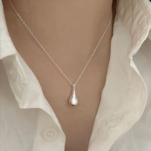 Minimalist 925 silver necklace with teardrop pendant worn on white cotton shirt