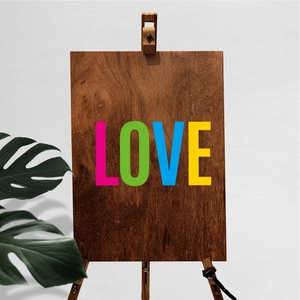 Close-up of wood letter sign with colorful LOVE print on a wooden display stand