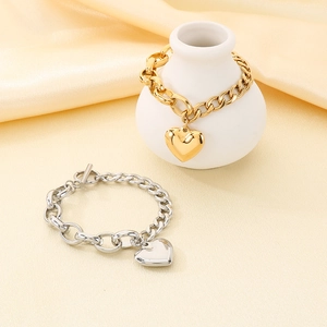 Detail of 18k gold and silver heart bracelets with vintage OT buckle on silk