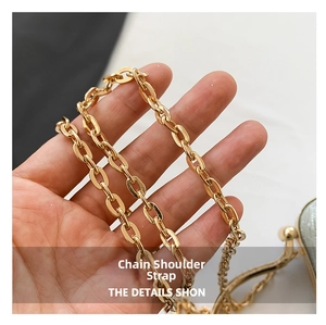 Detailed macro shot of the glossy gold metal chain strap for high-end elegant handbags