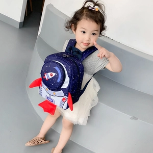 Toddler wearing a dark blue space rocket backpack with leash on stairs, detail shot