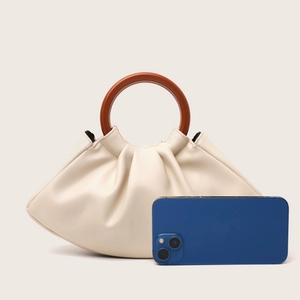 Beige pleated cloud bag with vintage brown wooden handles and smartphone size reference