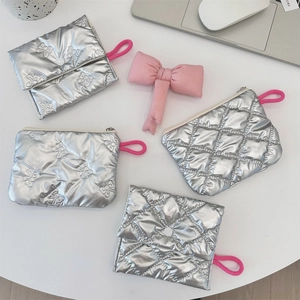 Detailed view of silver quilted pouches with zipper and flap closure with pink straps