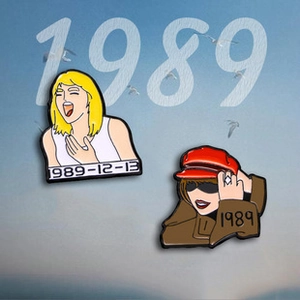 Detail view of two cartoon metal badges featuring character portraits and 1989 text