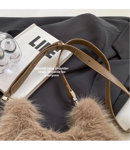 Detail shot of plush faux fur brown shoulder bag with adjustable leather strap and silver buckle