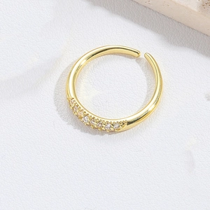 Macro shot of an adjustable gold open ring with sparkling cubic zirconia teardrop detail