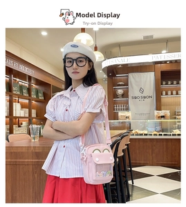 Pink canvas crossbody ita bag with clear window shown on a model in a cafe setting