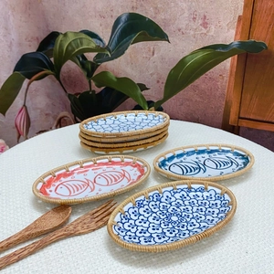 Oval ceramic serving tray with woven rattan edge and hand-painted blue fish patterns